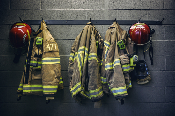 Equipamentos de proteção e uniformes de bombeiro civil organizados na academia